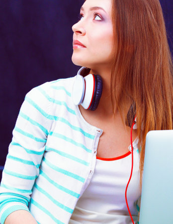 Young woman with laptop sitting on green grass . Portreit young womanの写真素材