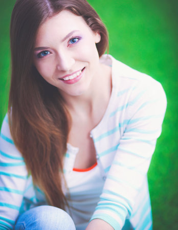 Young woman sitting on green grass . Portreit young womanの写真素材