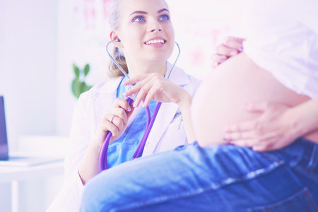 Young female doctor examining pregnant woman at the clinic.の写真素材