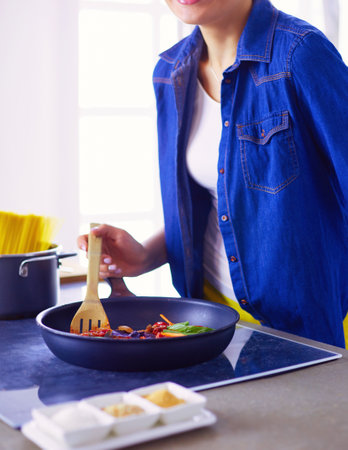 Young woman in the kitchen preparing a foodの写真素材