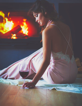 Sexy woman in front of the fireplace. Wood fireplace.の写真素材