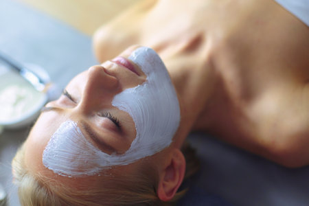 Face mask.Beautiful young girl at spa ,cosmetician woman applying facial mask.の写真素材