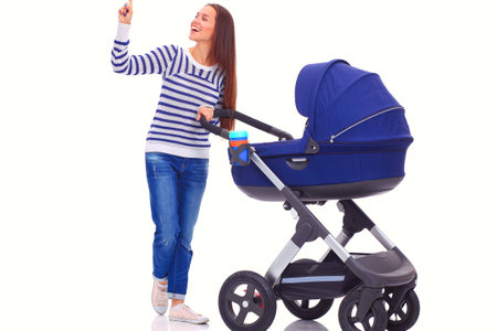 Full length portrait of a mother with a stroller, isolated on white background. Young momの写真素材