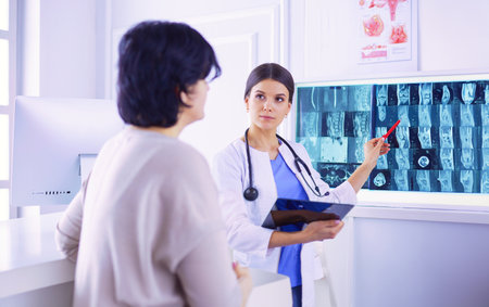 Medical consultation. Female doctor holding a patient by her shoulder, soothing her fearの写真素材