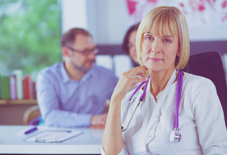 Doctor woman sitting with male patient at the deskの写真素材