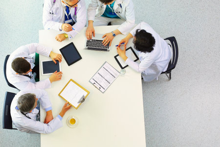 Medical team sitting and discussing at table, top viewの写真素材