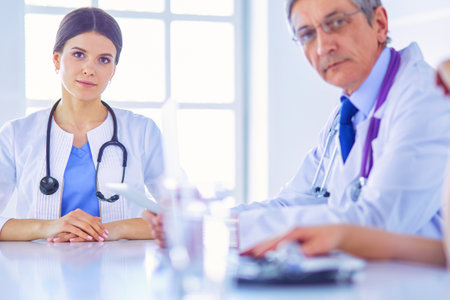 Serious medical team analysing a patients disease in a bright hospital roomの写真素材