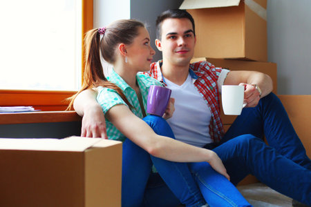 Couple moving in house sitting on the floor. Coupleの写真素材