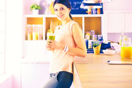 Beautiful young woman using a digital tablet in the kitchenの写真素材