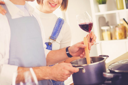 Couple cooking together in the kitchen at homeの写真素材