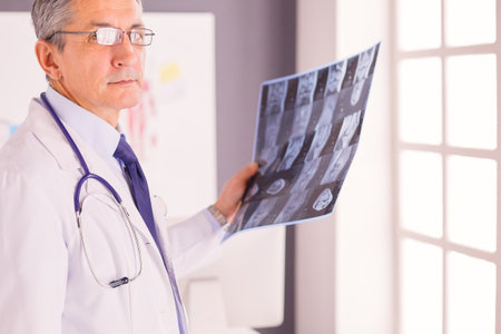 Male doctor writes notes on the clipboard in the hospitalの写真素材