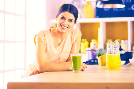 Young woman sitting a table in the kitchenの写真素材