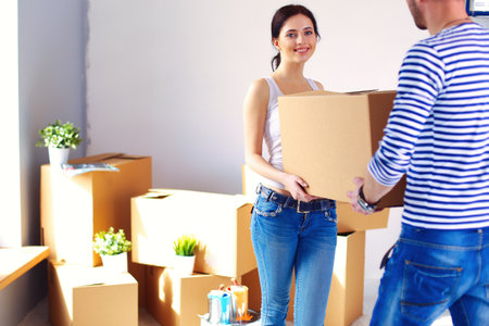 Happy young couple unpacking or packing boxes and moving into a new home. young coupleの写真素材