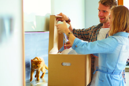 Young couple carrying big cardboard box at new home.Moving house. Young coupleの写真素材