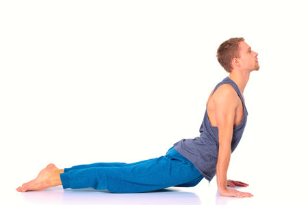 Adult man doing yoga exercise on white backgroundの写真素材