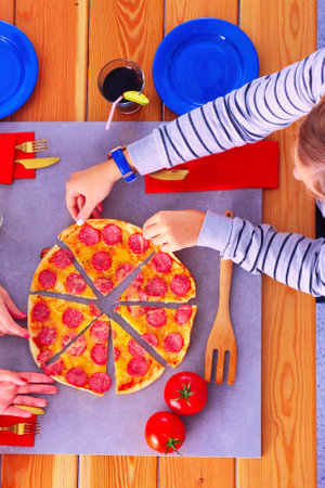 Top view of group of people having dinner together while sitting at wooden table. Food on the table. People eat fast food.の写真素材