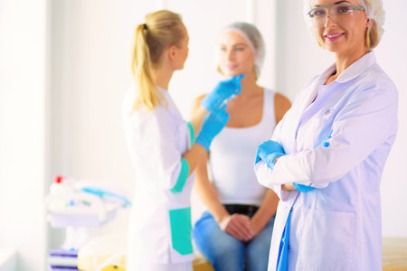 Beautiful woman face near doctor with syringe.の写真素材