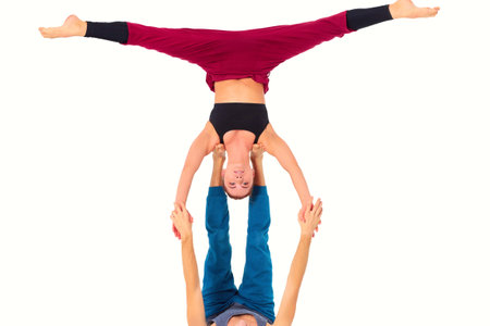 Young athletic couple practicing acroyoga. Balancing in pairの写真素材