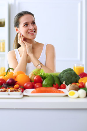 Young woman sitting a table in the kitchen .の写真素材