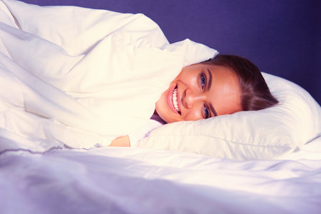 Beautiful young blonde woman sleeping in bedの写真素材