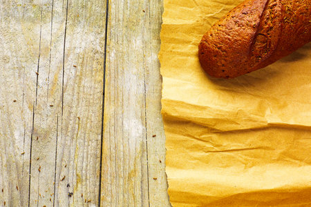 A loaf of Bread packed in paper on wooden table.の写真素材