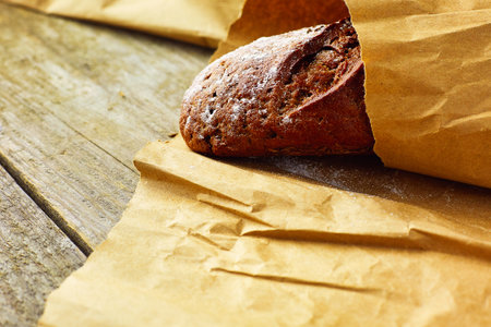 A loaf of Bread packed in paper on wooden table.の写真素材