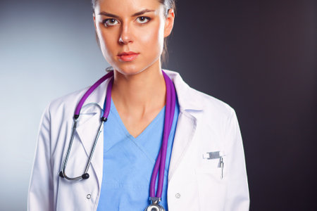 Young doctor woman with stethoscope isolated on greyの写真素材