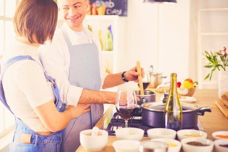 Couple cooking together in the kitchen at homeの写真素材