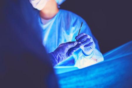 Doctor performing surgery in a dark background.の写真素材
