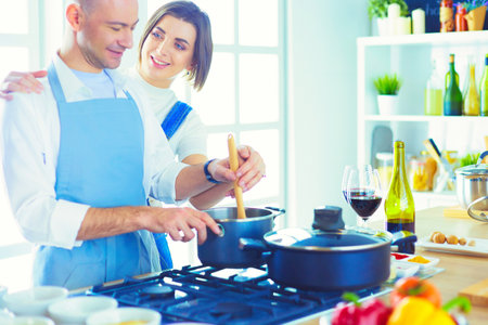 Couple cooking together in the kitchen at homeの写真素材
