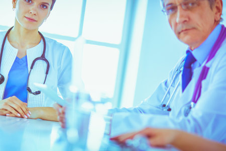 Serious medical team analysing a patients disease in a bright hospital roomの写真素材