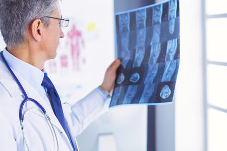 Male doctor writes notes on the clipboard in the hospitalの写真素材