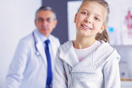 Portrait of a cute little girl and her doctor at hospitalの写真素材