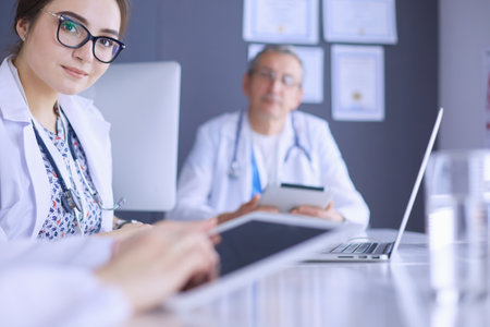Serious medical team using a laptop in a bright officeの写真素材