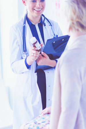 Doctor and patient discussing something while sitting at the table . Medicine and health care conceptの写真素材