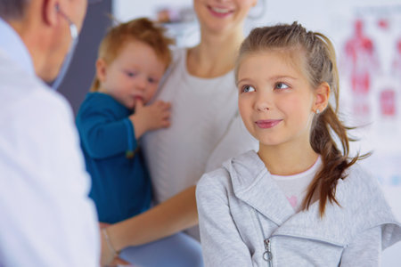 Girl and doctor with stethoscope listening to heartbeatの写真素材
