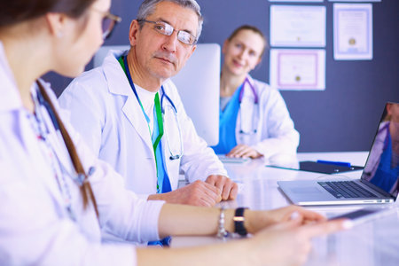 Serious medical team using a laptop in a bright officeの写真素材
