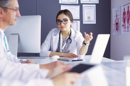 Serious medical team using a laptop in a bright officeの写真素材
