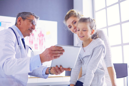 Portrait of a cute little girl and her doctor at hospitalの写真素材