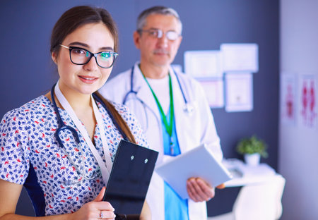A medical team of doctors, man and woman,standing in officeの写真素材