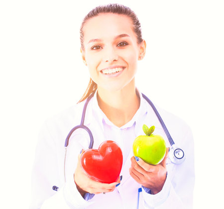 Beautiful smiling female doctor holding red heart and green apple. Woman doctorの写真素材