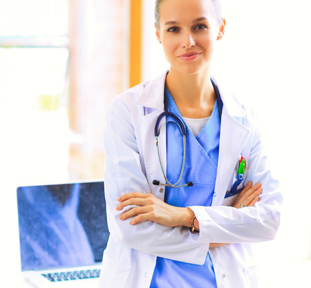 Woman doctor standing with medical stethoscope at hospitalの写真素材