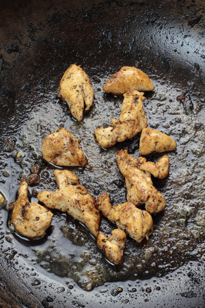 Pieces of chicken breast fried in wok.の写真素材