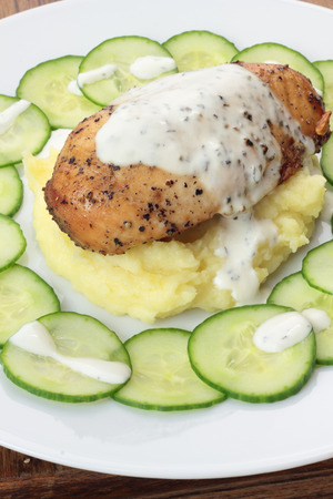 Closeup of roasted piece of chicken on mashed potatoes.の写真素材