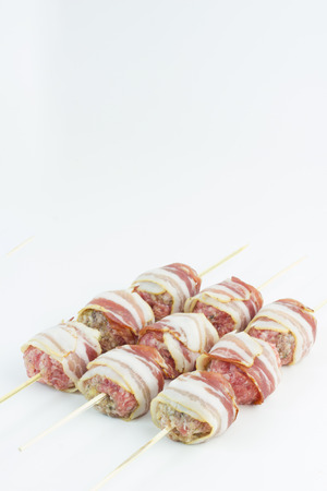 Bacon wraped meatballs skewers isolated on white.の写真素材