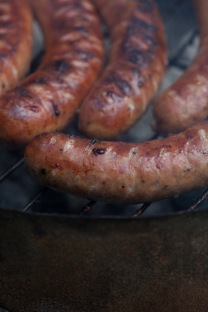 Traditional Polish sausages being prepared on a barbecue.の写真素材