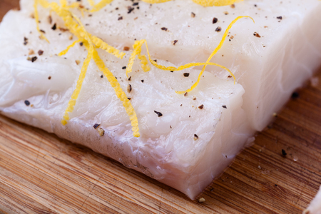 Closeup of Cod fillets seasoned with pepper and lemon zest.の写真素材