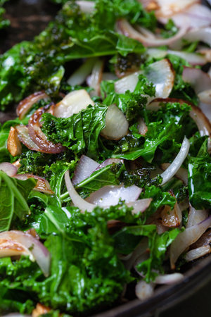 Kale with onions and garlic are being fried.の写真素材