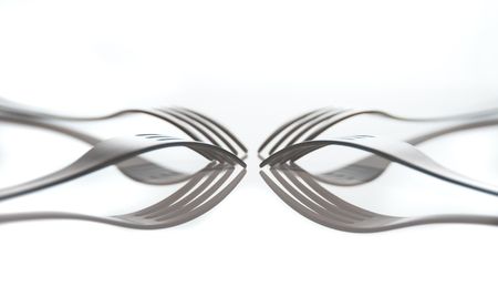 four forks on white reflected in table topの写真素材