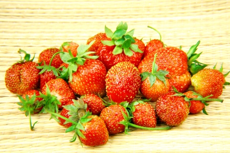 Garden strawberries on a straw backgroundの写真素材